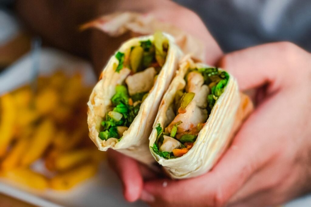 pexels-photo-10027451-10027451 Person Holding a Wrapped Meal with Vegetables Inside
